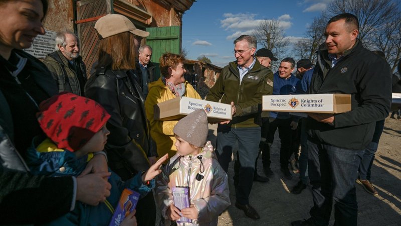Supreme Knight Patrick Kelly of the Knights of Columbus and Ukraine State Deputy Youriy Maletskiy, a leader of the Knights in Lviv, deliver Easter care packages April 12, 2022, to Ukrainian families at a 14th-century monastery in Rava-Ruska in the Lviv Archdiocese. The families, been displaced by war, were taking refuge in the monastery in western Ukraine. (OSV News photo/Tamino Petelinsek, courtesy Knights of Columbus)