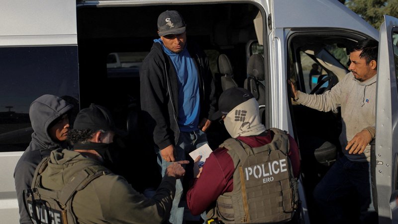 U.S. Immigration and Customs Enforcement agents check the identity document of an agricultural worker at a grocery store parking lot during an immigration raid in Mecca, Calif., Dec. 19, 2025. According to a new economic study released in early May 2026, the Trump administration's mass deportation efforts could have a significant chilling effect on the economy and the labor market, including for U.S.-born workers. (OSV News photo/Daniel Cole, Reuters)