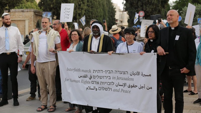 Father Piotr Zelazko, a Polish priest who serves as the patriarchal vicar for the St. James Vicariate for the Hebrew-speaking Catholics in Israel, is seen marching in the interfaith peace march of the Forum for Human Rights in Jerusalem May 18, 2026, with those of other faiths. Religious sisters, priests, and rabbis gathered on the grounds of the YMCA alongside young people with piercings, families and ultra-Orthodox Jews for the opening ceremony, which included a prayer asking for God's mercy sung in Aramaic by Jerusalem Christian resident Nadeen Fanous. (OSV News photo/courtesy Jacob Lazarus)