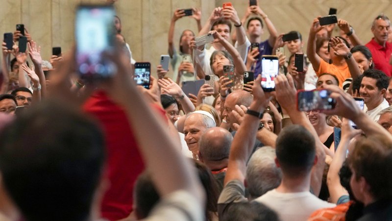 In this file photo from June 14, 2025, Pope Leo XIV greets people as they hold up cellphones to take photos and videos as he enters St. Peter’s Basilica for an audience with pilgrims in Rome for the Holy Year 2025. (CNS/Lola Gomez)