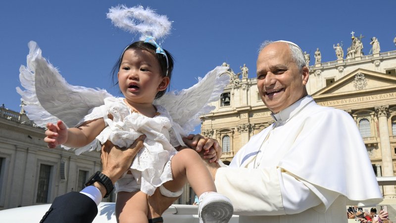 Pope Leo XIV greets a child from the popemobile while riding around St. Peter’s Square at the Vatican before his weekly general audience June 17, 2026. (CNS photo/Vatican Media)