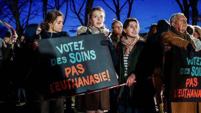 People hold placards reading, "Vote for care. Not euthanasia," during a demonstration in Paris Feb. 16, 2026, as France debates a bill to legalize "assisted dying." The bishops of France urged the faithful to take part in a novena that began June 21, as lawmakers move closer to a pivotal vote on legislation that could permanently legalize "assisted dying" in the country. (OSV News photo/Benoit Tessier, Reuters)