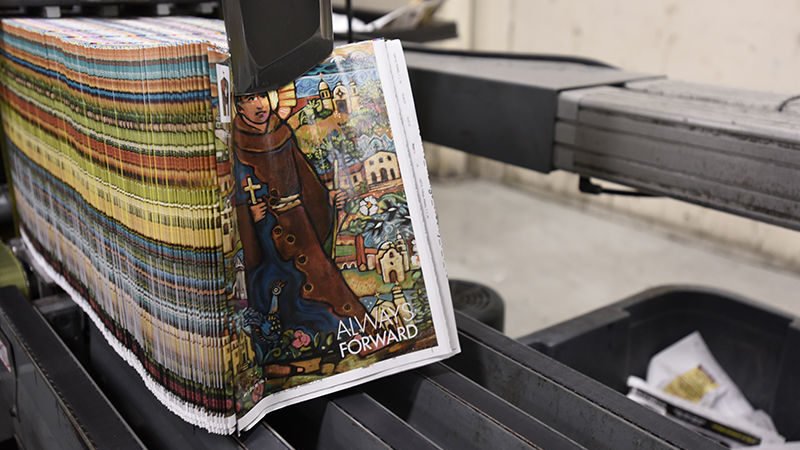 A stack of the debut issue of Angelus News magazine comes off the press. (Tamara Long Garcia)