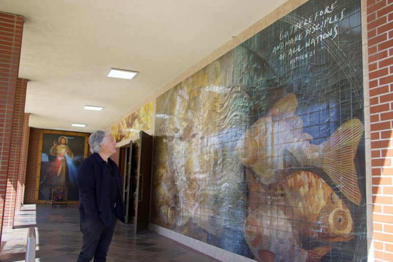 José García Moreno looks over the new tile mural he created at Holy Family Church in Artesia, which has a “fishers of men” theme. (Kimmy Chacon)