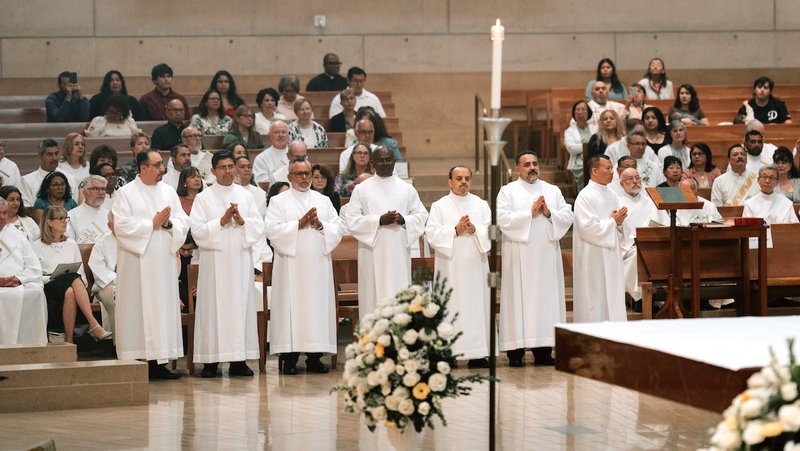 The seven men to be ordained as permanent deacons stand on the side of the altar to begin the ordination Mass at the Cathedral of Our Lady of the Angels on June 6. (Peter Lobato)