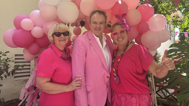 Father Tomas Karanauskas, center, the pastor at St. Casimir Church in Los Feliz, shows off his pink-colored blazer in honor of Lithuania’s signature chilled beet soup during the parish’s ‘Atlaidai’ anniversary celebration on May 31. At left is parish secretary Vitalia Virbukiene, and at right is festival master of ceremonies Justina Brazdzionis. (Natalie Romano)