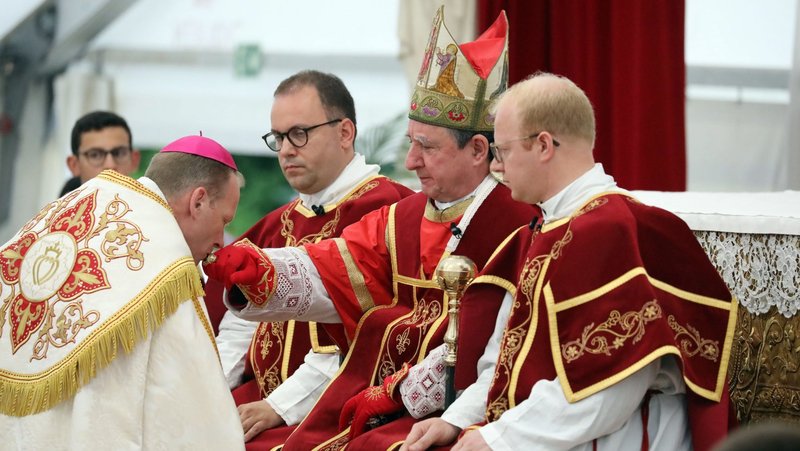 Newly consecrated Society of St. Pius X Bishop Michael Goldade, an American, is seen kissing the ring of Bishop Alfonso de Galarreta during an SSPX liturgical celebration July 1, 2026, in Écône, Switzerland. The two bishops, along with with Bishop Bernard Fellay of SSPX and three other newly consecrated bishops were excommunicated by the Vatican July 2, as the consecration lacked the mandate of the pope and was decreed to be schismatic. (OSV News photo/CPP)