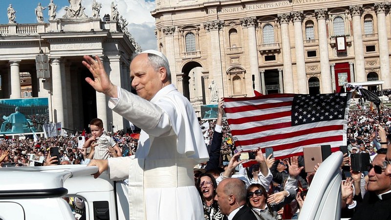 An American flag is displayed as Pope Leo XIV, formerly Cardinal Robert F. Prevost, waves as he arrives to celebrate his inauguration Mass at the Vatican May 18, 2025. In 2026, Pope Leo --the first American pope in history-- sent a letter to all Americans on the occasion of the 250th anniversary of the country's independence. (OSV News photo/Andy Abeyta, Reuters)