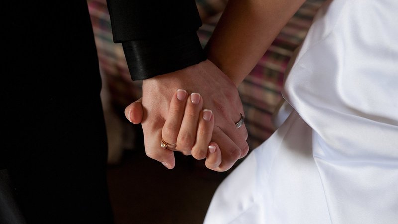 A groom and bride hold hands on their wedding day. (OSV News file photo/Jon L. Hendricks)