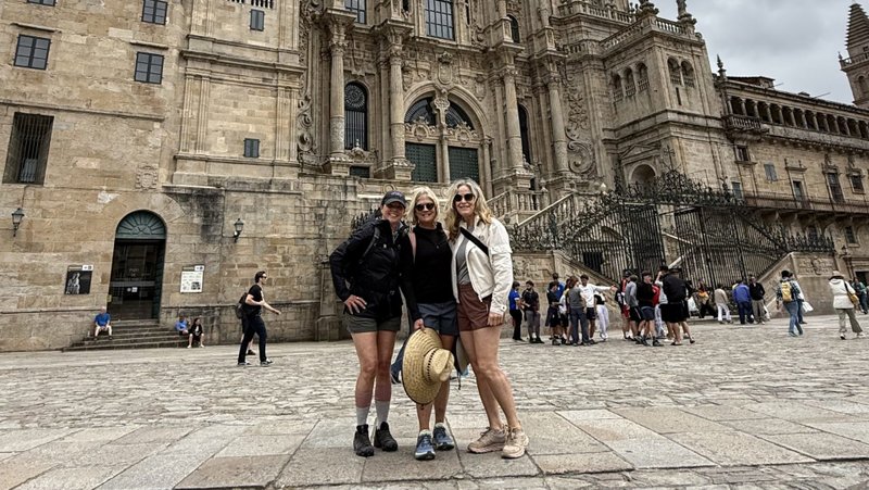 The author, left, and her two friends upon reaching the Cathedral of Santiago de Compostela in June. (Heidi Johnson)