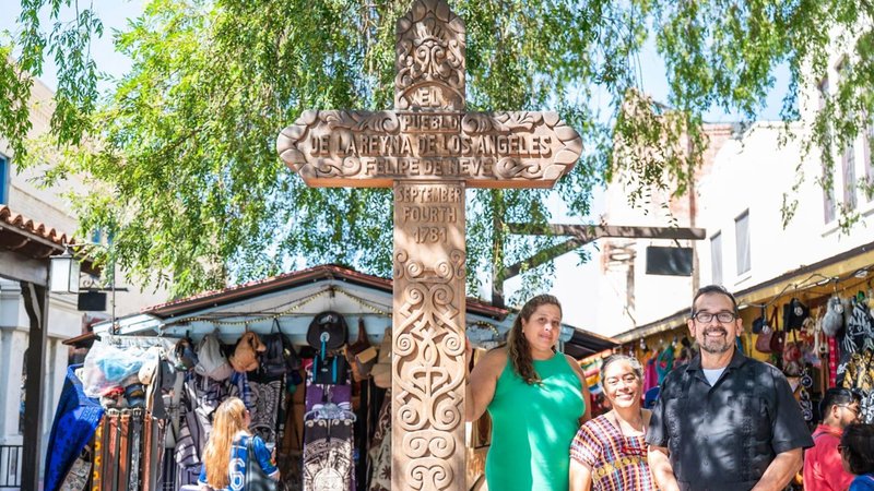 Los Angeles merchants Sylvia Gribbell, Valerie Hanley, and Eddie Flores stand next to the Olvera Street cross in Los Angeles. (Becket via EWTN)