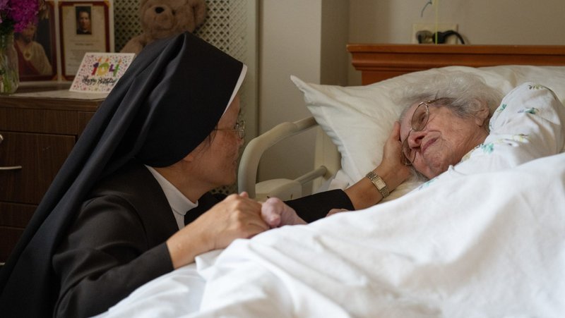 A Carmelite Sister comforts a resident Aug. 21, 2026, at St. Patrick’s Residence in Naperville, Ill. Cardinal Blase J. Cupich of Chicago, the Carmelite Sisters for the Aged and Infirm and the Chicago Province of the Little Sisters of the Poor, and an Illinois pharmacist sued Illinois Sept. 3 over the state's physician-assisted suicide law, which permits physicians to aid terminally ill adults in dying by suicide. (OSV News photo/courtesy Becket)
