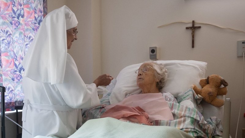 A sister serves a resident Aug. 19, 2026, at St. Patrick’s Residence in Naperville, Ill. Cardinal Blase J. Cupich of Chicago, the Carmelite Sisters for the Aged and Infirm and the Chicago Province of the Little Sisters of the Poor, and an Illinois pharmacist sued Illinois Sept. 3 over the state's physician-assisted suicide law, which permits physicians to aid terminally ill adults in dying by suicide. (OSV News photo/courtesy Becket)