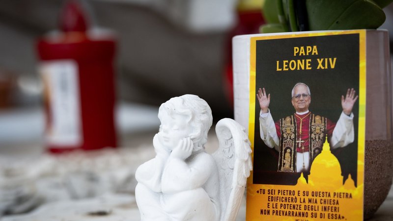 A photo of Pope Leo XIV is placed near devotional items on the statue of St. John Paul II in front of Rome's Gemelli hospital where the pope is recovering from surgery during which doctors removed his lower right lung to treat a cancerous tumor. (CNS photo/Cristian Gennari)