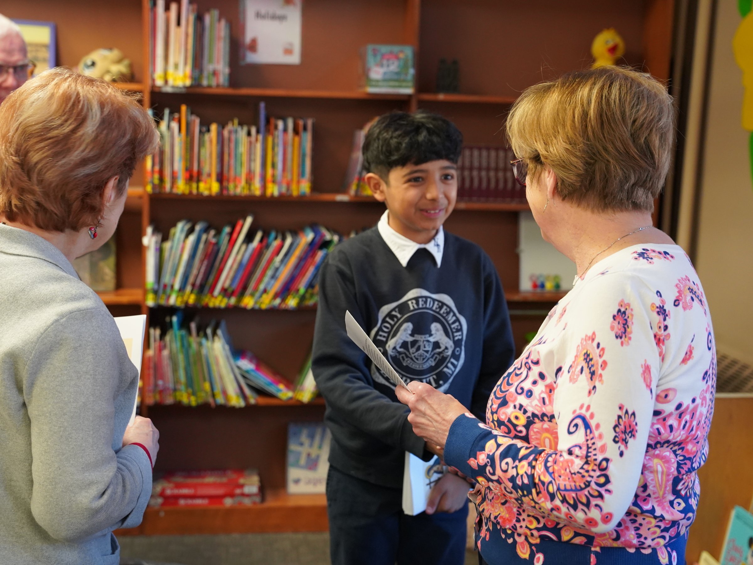 Sixth-grader Ivan Rodriguez speaks with a supporter about the Marian Project.