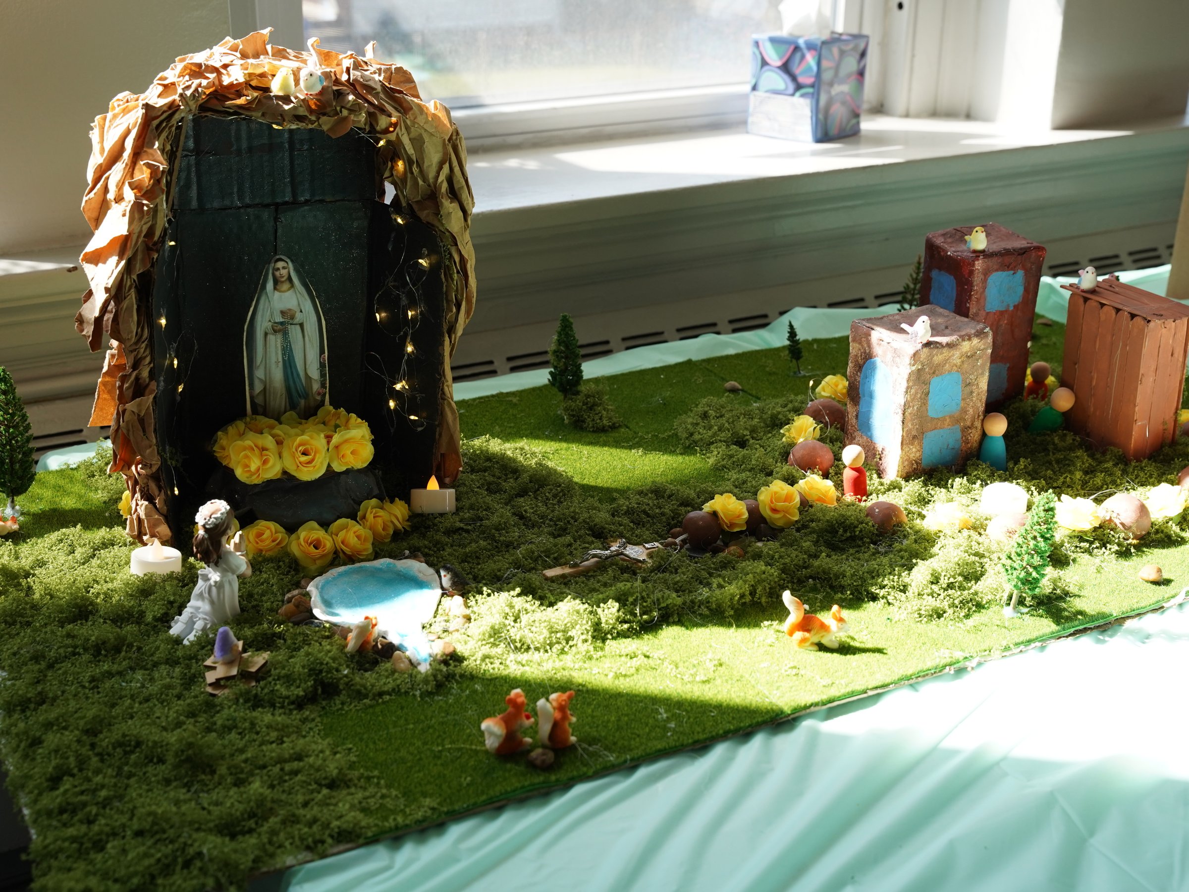 A student display spotlighting Our Lady of Lourdes.