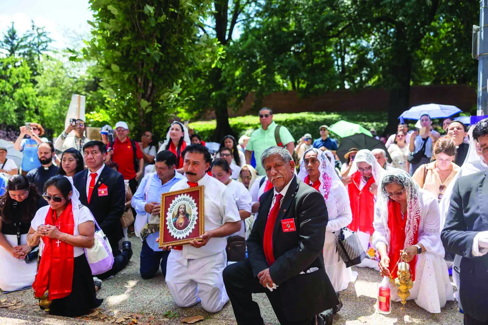 Above and below, Catholics pray and sing hymns during a Eucharistic procession through the streets of Washington held in solidarity with immigrants on the feast of Corpus Christi. (Catholic Standard photo by Mihoko Owada)