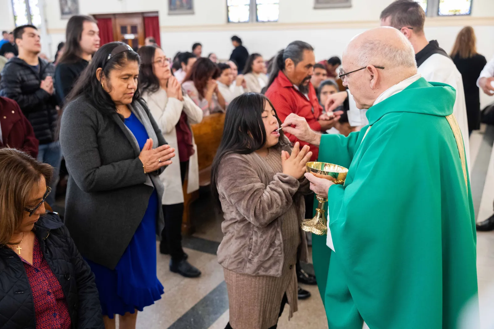 Father Pablo Bonello, a priest of the Institute of the Incarnate Word who serves as the pastor of St. James Parish in Mount Rainier, Maryland, gives Communion to a girl during a Mass on Oct. 25, 2026 marking the 100th anniversary of St. James Church in Mount Rainier, Maryland. (Catholic Standard photo by Andrew Biraj)