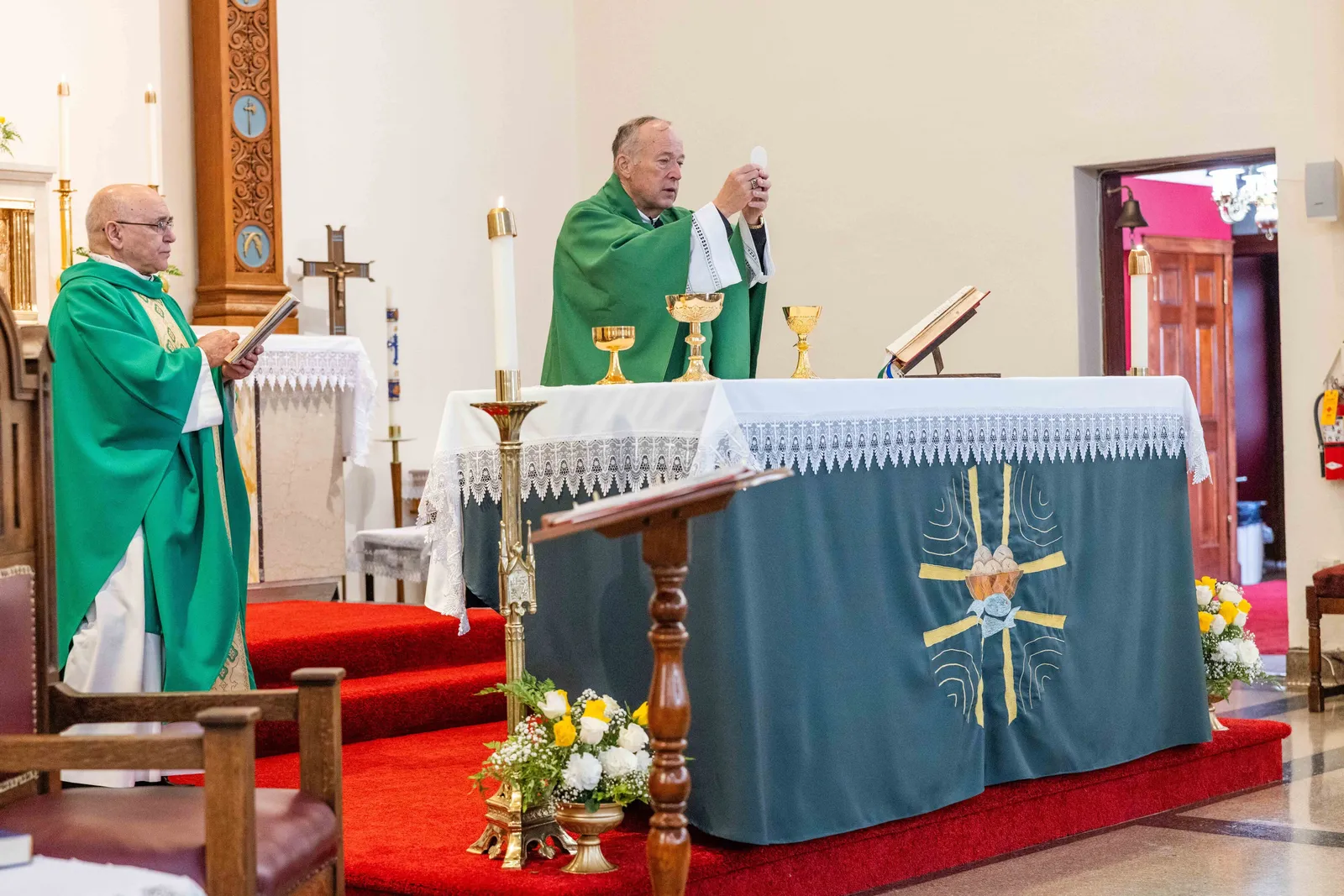 Washington Cardinal Robert W. McElroy elevates the Eucharist during a Mass on Oct. 25, 2026 marking the 100th anniversary of St. James Church in Mount Rainier, Maryland. At left is Father Pablo Bonello, a priest of the Institute of the Incarnate Word who serves as St. James’ pastor. (Catholic Standard photos by Andrew Biraj)