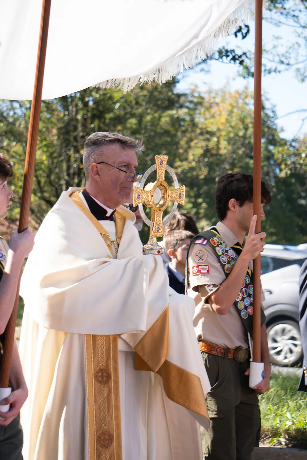 Msgr. Charles J. Parry, the pastor of St. Patrick Parish in Rockville, Maryland, holds the monstrance during an outdoor Eucharistic procession that followed a Mass at St. Patrick Church on Oct. 18, 2026 marking the parish’s 60th anniversary. In the photos below, parishioners join the Eucharistic procession that wound from Manor Country Club to St. Patrick Church. (Catholic Standard photos by Margaret Ardillo)