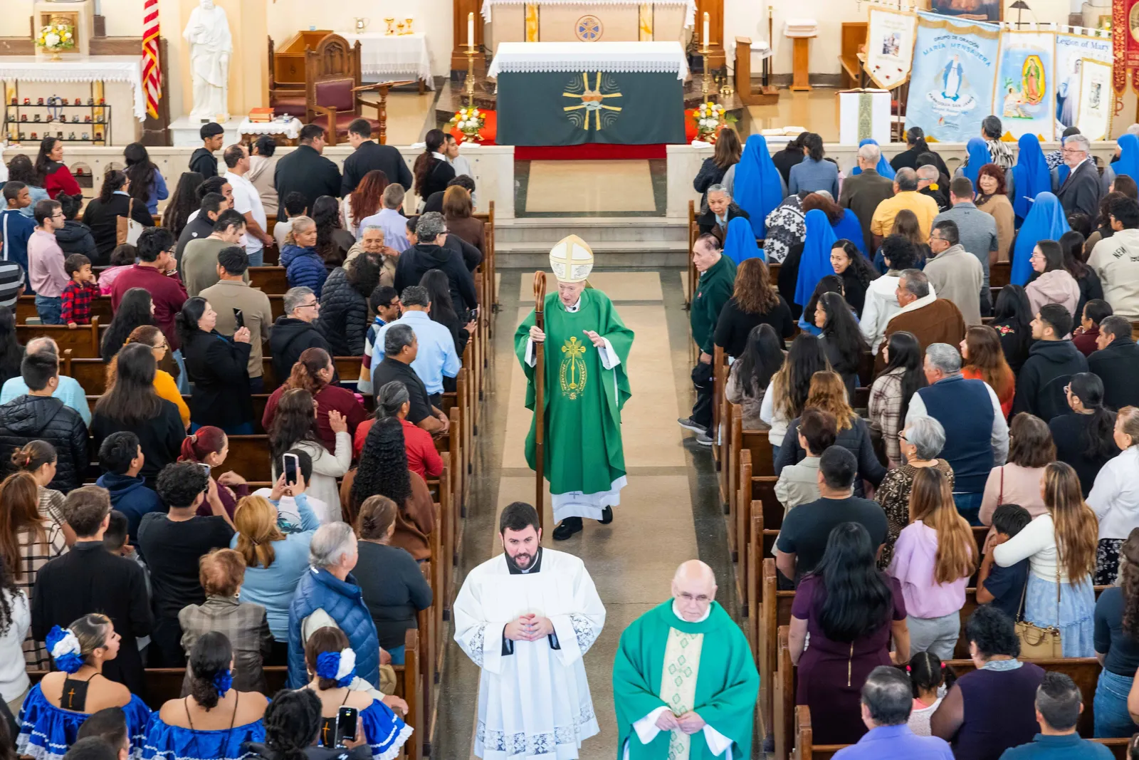 After celebrating a Mass on Oct. 25, 2026 marking the 100th anniversary of St. James Church in Mount Rainier, Maryland, Washington Cardinal Robert W. McElroy processes from the altar. Walking ahead of him at left is Father Thomas Robertson, the cardinal’s priest secretary, and at right is Father Pablo Bonello, a priest of the Institute of the Incarnate Word who serves as the pastor of St. James Parish. (Catholic Standard photo by Andrew Biraj)