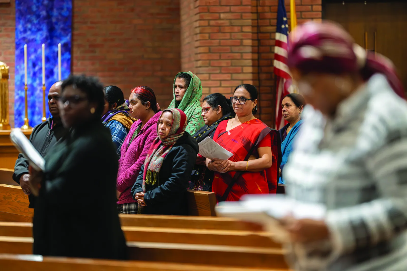 Above and below, members of the St. Camillus community take part in a multilingual Stations of the Cross, listening to testimonies gathered from parish outreach efforts at the Catholic Center in Langley Park. (Catholic Standard photos by Denniss Olea)