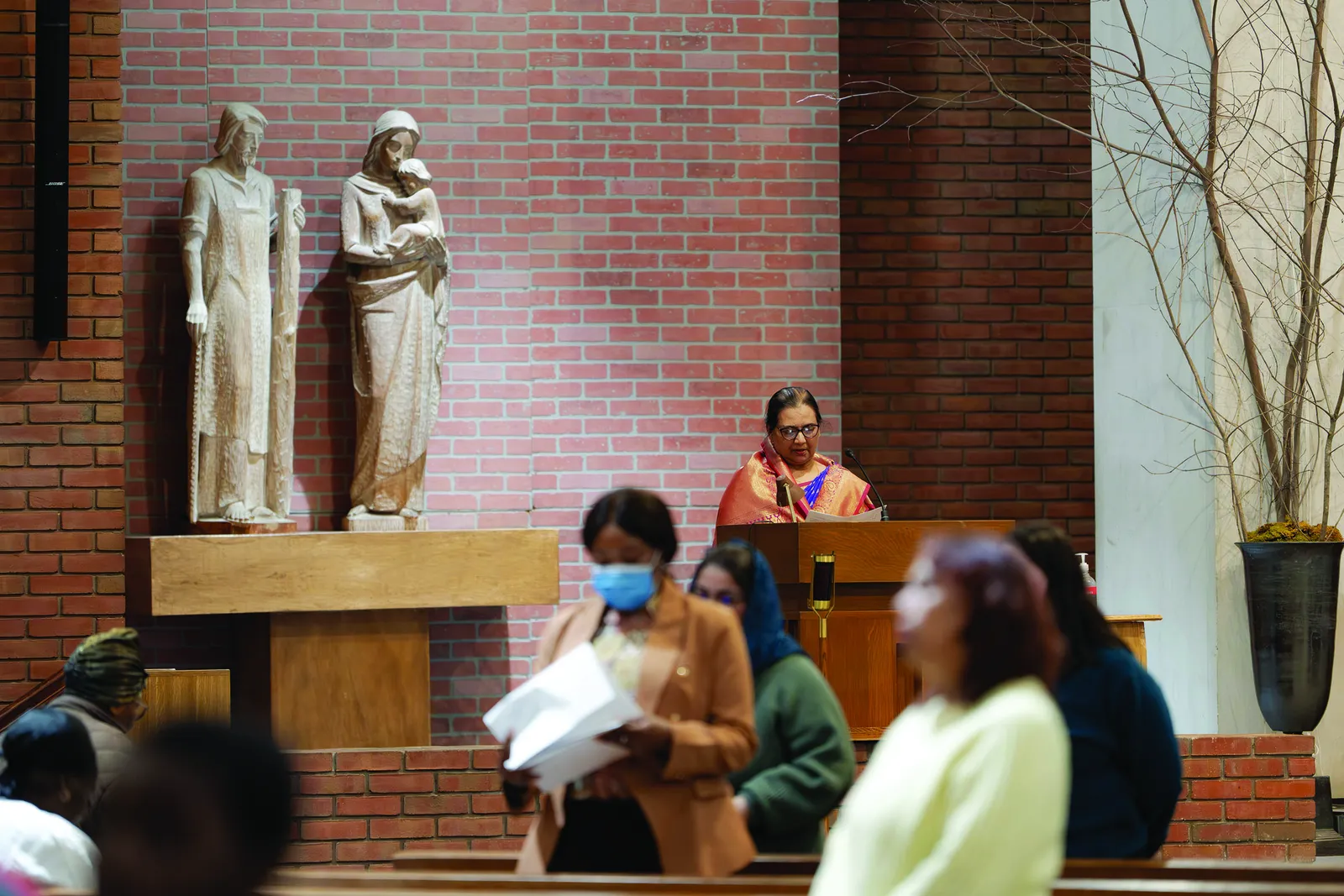 A participant reflects during a multilingual Stations of the Cross at St. Camillus Parish, where voices from the parish’s immigrant communities were incorporated into each station. (Catholic Standard photo by Denniss Olea)