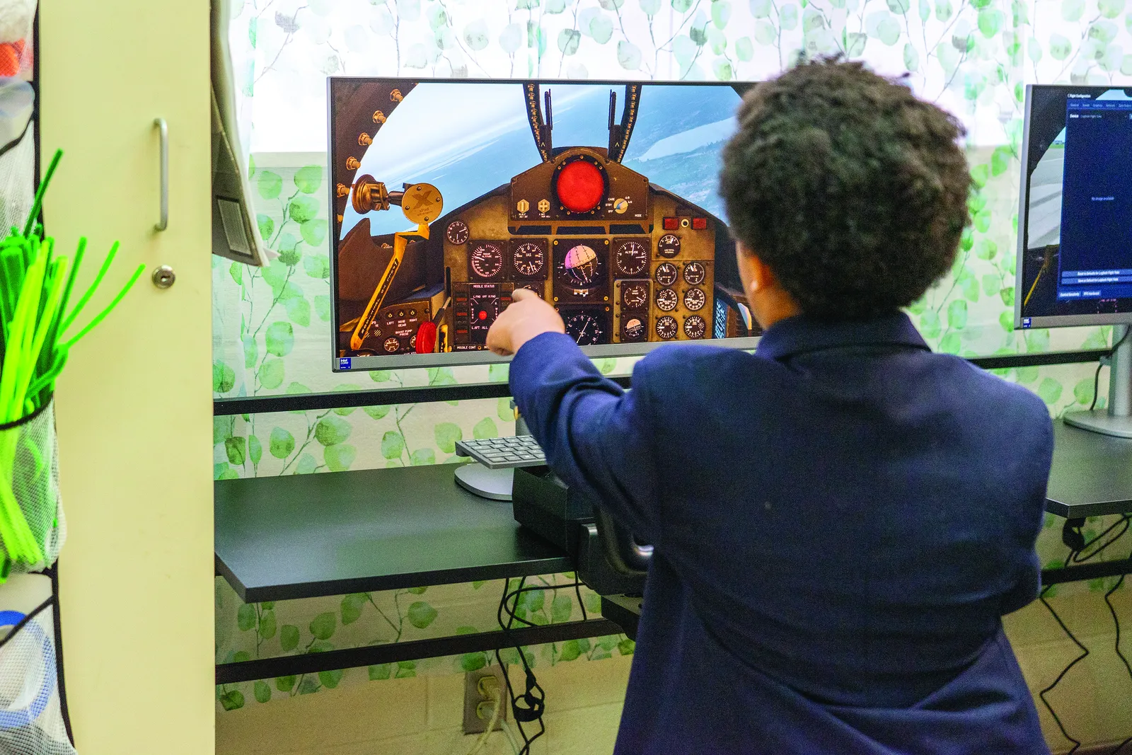 Seventh grader Jackson Alexander explains how the flight simulator program works, highlighting the different types of airplanes students can learn to fly. The simulators, brought to St. Peter’s School in Waldorf, Md., through a Civil Air Patrol grant, provide hands-on opportunities to explore aviation and STEM concepts. (Catholic Standard photo by Nicole Olea)
