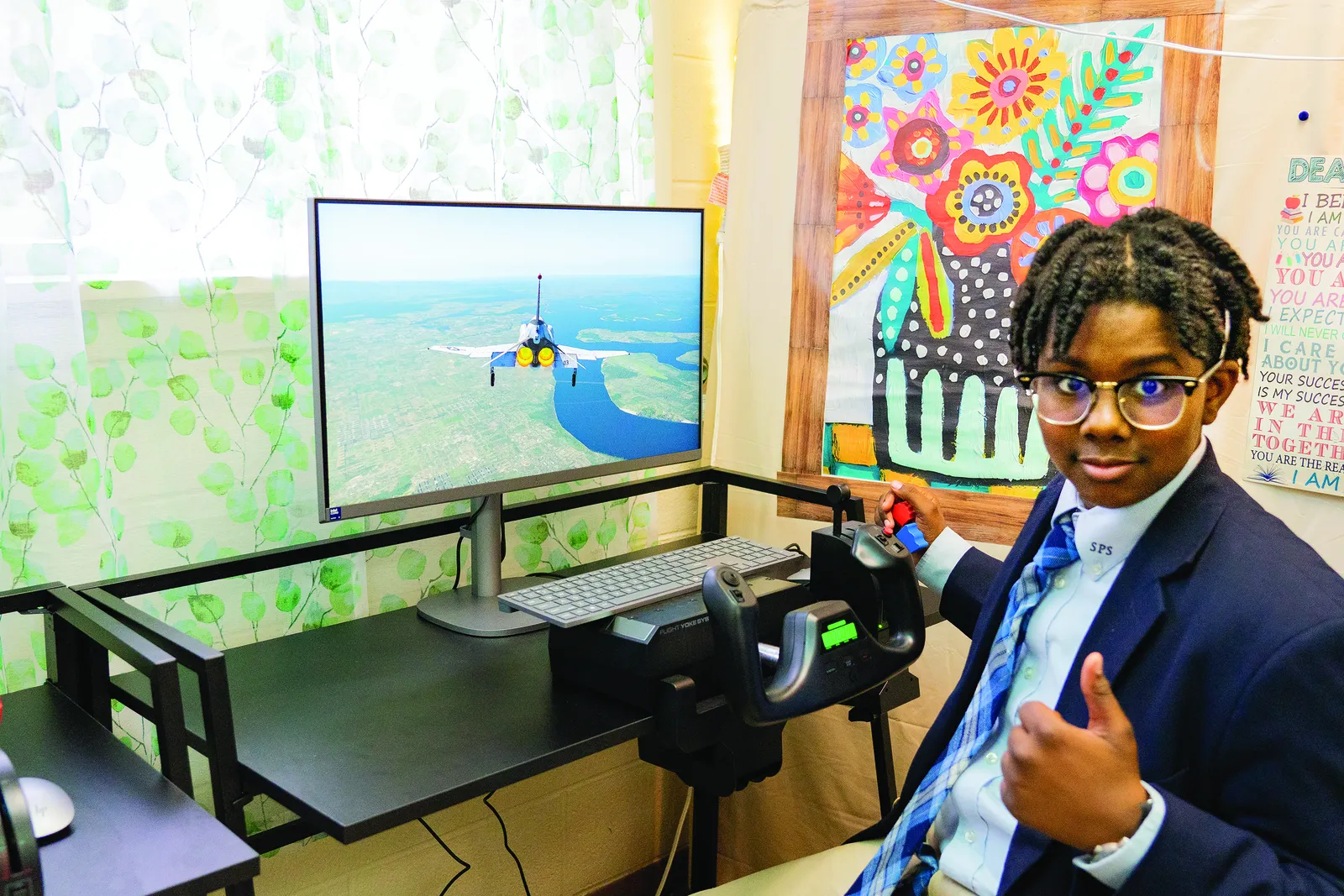 Eighth grader Christian Turner gives a thumbs-up while navigating a flight simulator in the STEM classroom at St. Peter’s School in Waldorf, Maryland. The flight simulators are part of the school’s innovative program to introduce students to aviation and aerospace concepts. (Catholic Standard photo by Nicole Olea)