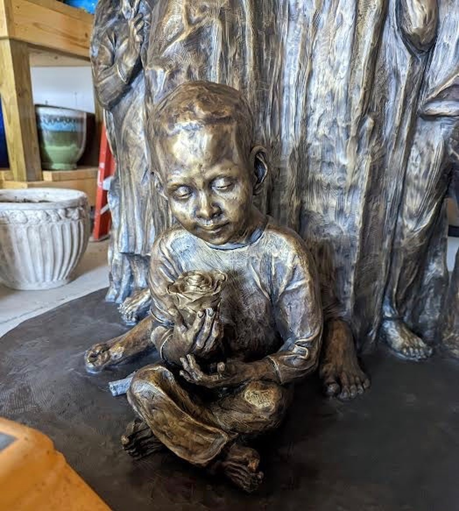 A boy is depicted picking roses while sitting at Mary's feet. (Courtesy of Mary Dudek)
