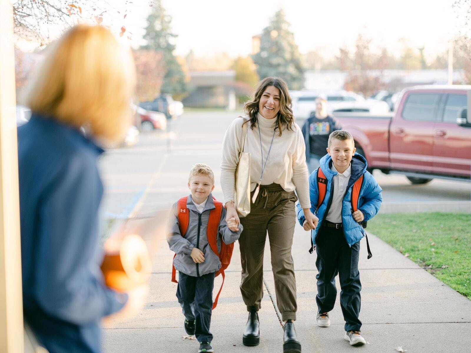 A mother walks her two boys into Our Lady of the Lakes School in Waterford on the first day of school.