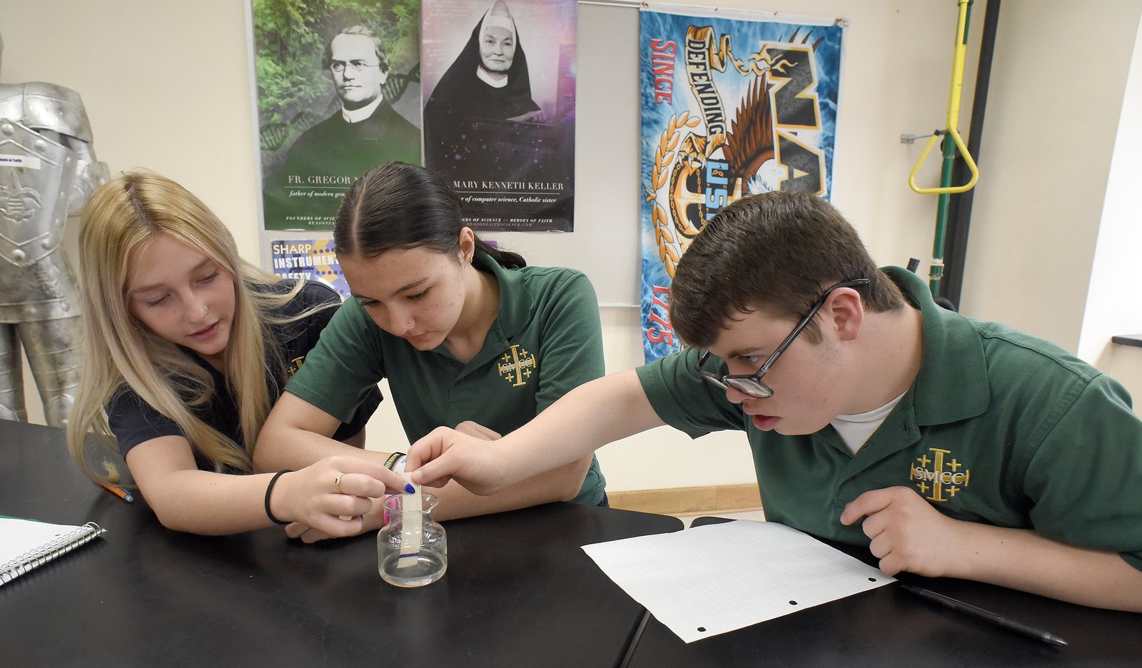 St. Mary Catholic Central (SMCC) sophomores (from left) Avery Towne, Paxton Ball, and Gavin O’Kelley work together on a science experiment. O’Kelley is a member of the St. Andre Bessette Open Doors Inclusion program for SMCC students with special learning needs. (Photo by Tom Hawley, Monroe News | Courtesy of Michigan Catholic Conference)