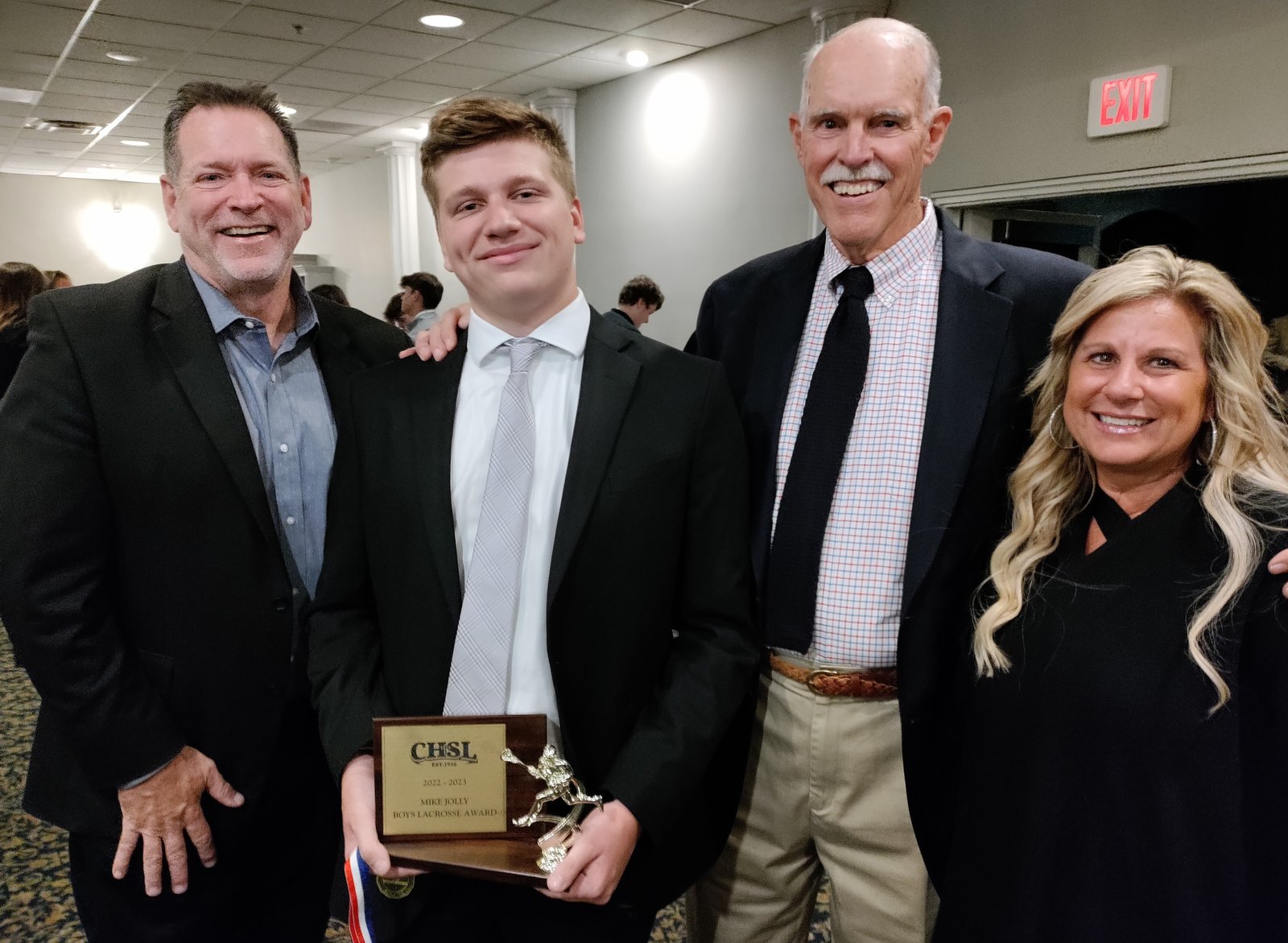 De La Salle grad Collin Bailey holds the lacrosse scholar athlete award handed to him by Mike Jolly, the man on his left after whom the award is named for his statewide promotion of the sport. Collin’s father, David, and mother, Cheryl, share their son’s achievement. Collin will be seeking a mechanical engineering degree from Michigan State University. About academics, a 4.3 student, Collin said: “I enjoy putting in the work and seeing the results. I hope this will give me a step up in life.”