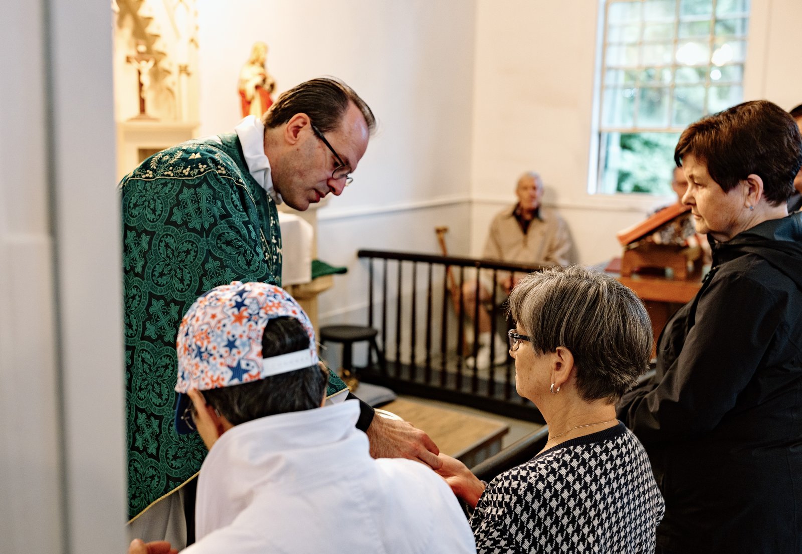 El P. David Cybulski, moderador y párroco solidario en St. Patrick, distribuye la Comunión durante la misa dentro de la histórica capilla el 27 de mayo.