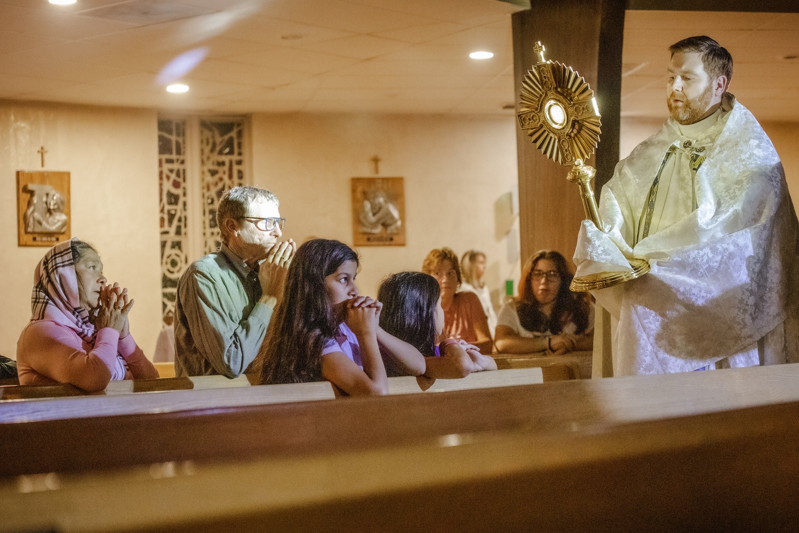 Fr. Stephen Pullis holds a monstrance containing the Blessed Sacrament blessing teens and adults gathered at St. Ronald Parish in Clinton Township as part of a special "Come, Encounter Christ" event Oct. 23. (Alissa Tuttle | Special to Detroit Catholic)