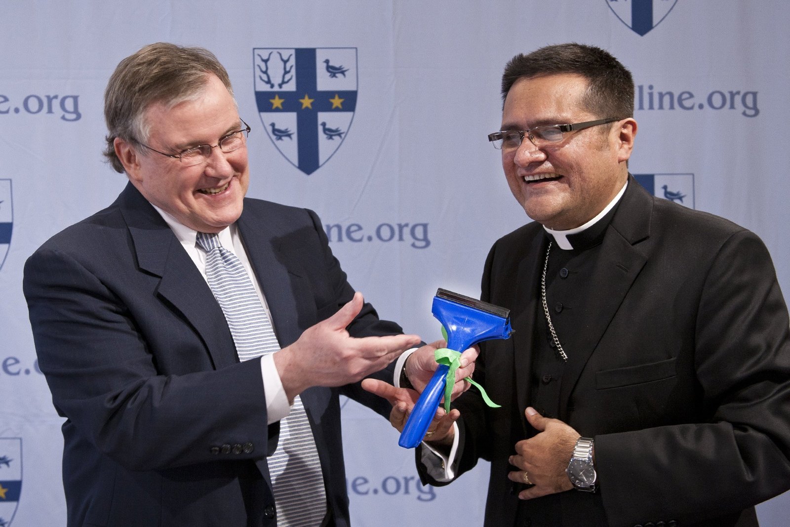 Ned McGrath, then director of communications for the Archdiocese of Detroit, presents an ice scraper to Bishop-designate Arturo Cepeda during his introduction at Sacred Heart Major Seminary in Detroit April 18, 2011. Bishop Cepeda, a native of Mexico, who lived much of his life in sunny San Antonio, jokingly asked if the scraper came with an instruction manual. (Larry Peplin | Michigan Catholic file photo)