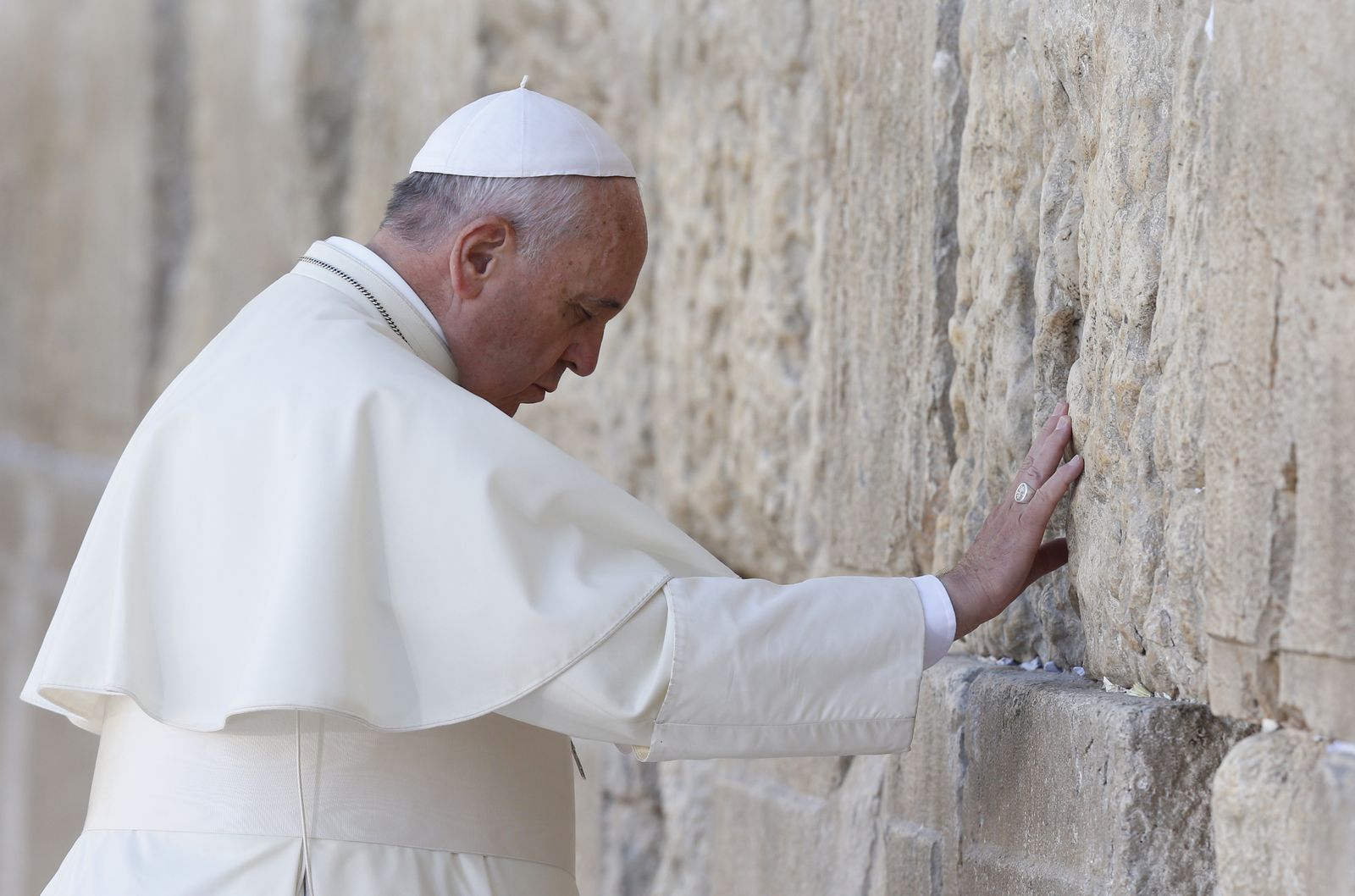 Pope Francis prays at the Western Wall in Jerusalem May 26. The pope stood for more than a minute and a half with his right hand against the wall, most of the time in silent prayer, before reciting the Our Father. Then he followed custom by leaving a written message inside a crack between two blocks.(CNS photo/Paul Haring)