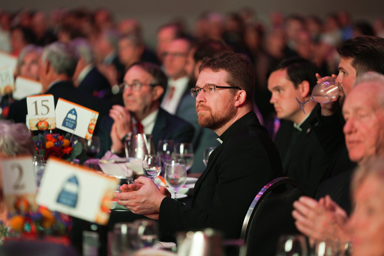 El Padre David Tomaszycki aplaude junto a otros invitados durante la Gala del Arzobispo el 10 de junio en Huntington Place en el centro de Detroit.