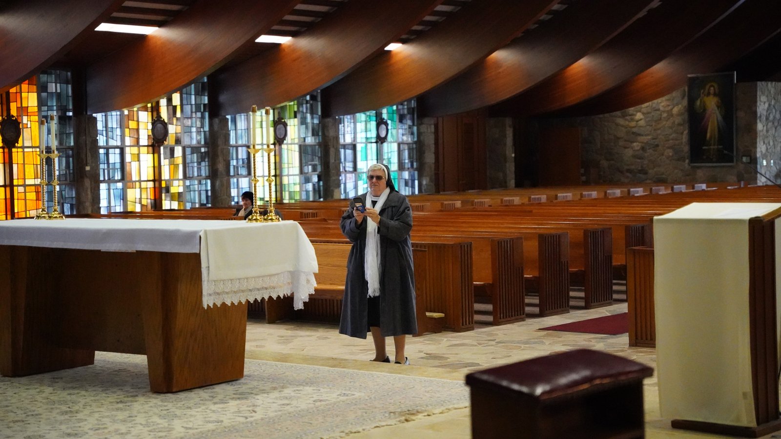 A religious sister takes a picture inside the Chapel of Our Lady of Orchard Lake at the center of the Orchard Lake Schools' campus.