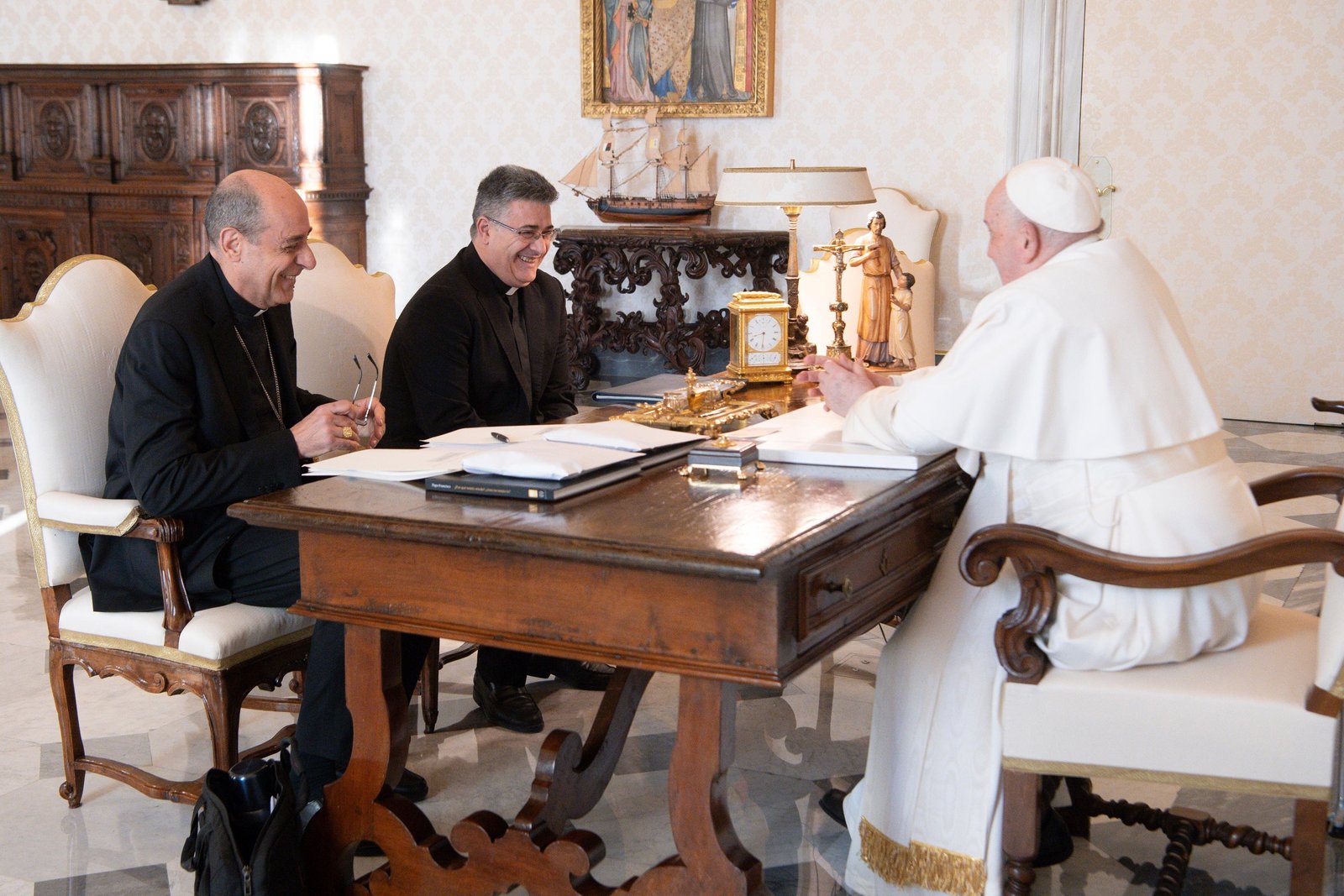 El Papa Francisco se ríe junto al Cardenal Víctor Manuel Fernández, a la derecha, prefecto de la Congregación para la Doctrina de la Fe, y Mons. Armando Matteo, secretario de la sección doctrinal de la congregación, durante una reunión en la biblioteca del Palacio Apostólico en el Vaticano el 18 de diciembre de 2023. (Foto CNS/Vatican Media)
