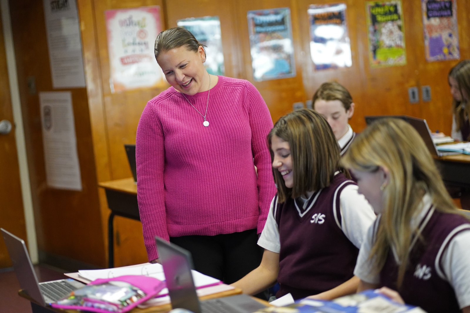 La maestra de estudios sociales Mary Bradley sonríe mientras revisa las tareas de los estudiantes durante una clase de octavo grado en St. William the Abbot School en Seaford, Nueva York, 13 de diciembre de 2023. (Foto de OSV News/Gregory A. Shemitz)