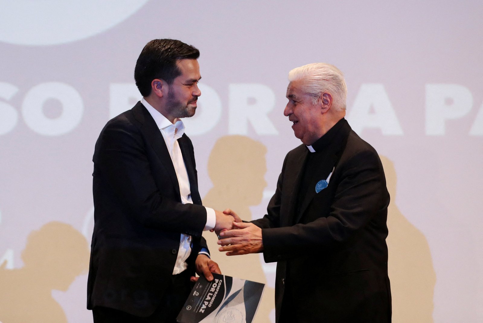 El candidato presidencial del partido Movimiento Ciudadano, Jorge Álvarez Maynez, estrecha la mano del Arzobispo Rogelio Cabrera López de Monterrey, México, el 11 de marzo de 2024, durante un evento en la Ciudad de México para firmar un compromiso de paz organizado por miembros de la Iglesia Católica. (Foto de OSV News/Raquel Cunha, Reuters)