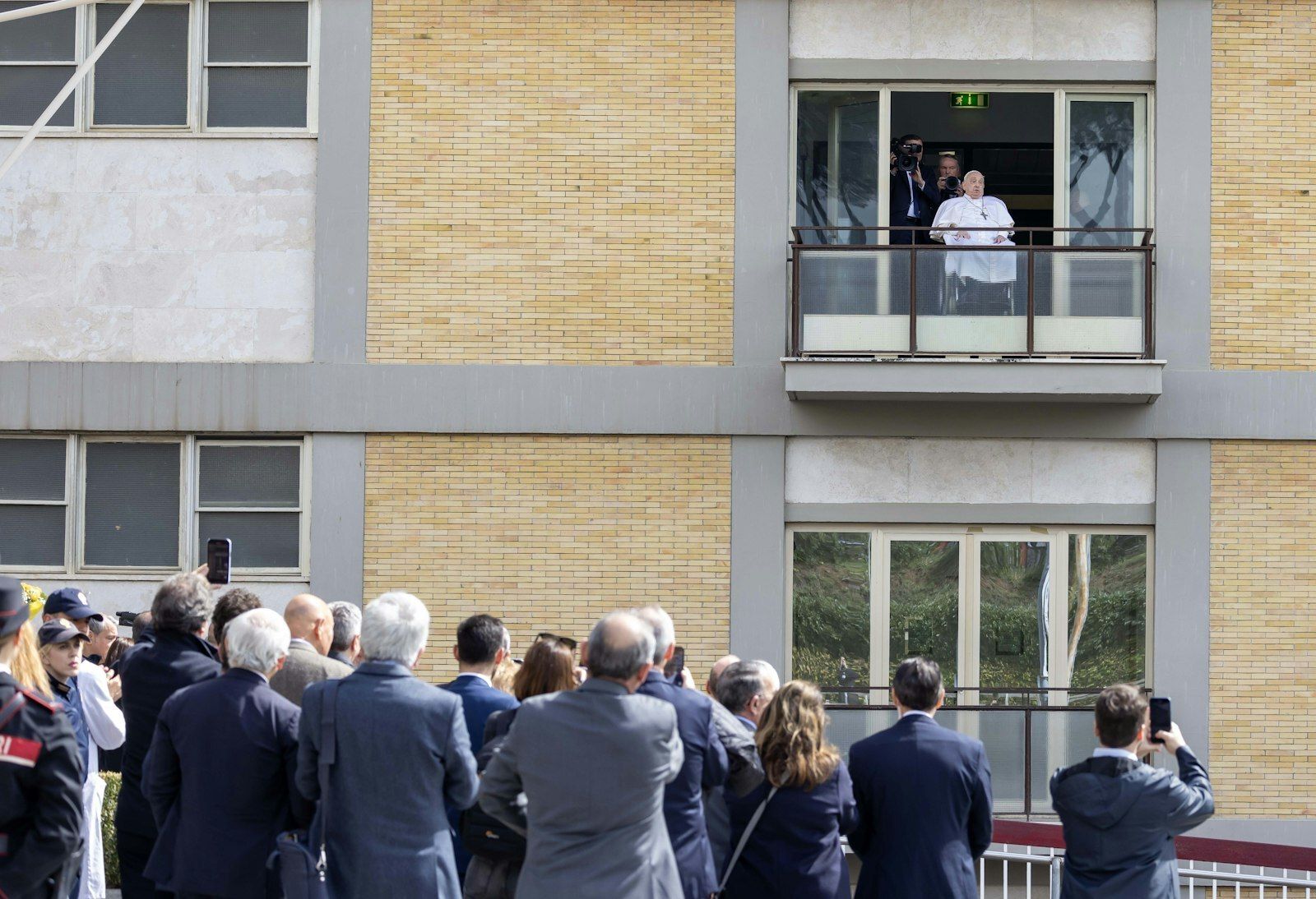 Las personas observan y toman fotos mientras el Papa Francisco saluda a una multitud de fieles en el hospital Gemelli de Roma antes de regresar al Vaticano el 23 de marzo de 2025, tras 38 días de tratamiento. (Foto de CNS/Pablo Esparza)