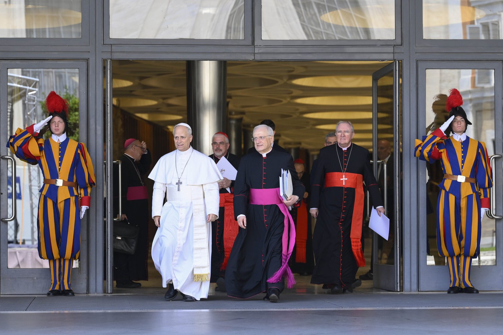 Pope Leo XIV leaves the Vatican's Paul VI Hall after meeting with the College of Cardinals May 10, 2025, for his first formal address to the college since his election May 8. To the right of the pope are: Cardinal Fabio Baggio, undersecretary of the Dicastery for Promoting Integral Human Development; Msgr. Leonardo Sapienza, an official of the Prefecture of the Papal Household; and Cardinal Arthur Roche, prefect of the Dicastery for Divine Worship and the Discipline of the Sacraments. (CNS photo/Vatican Media)