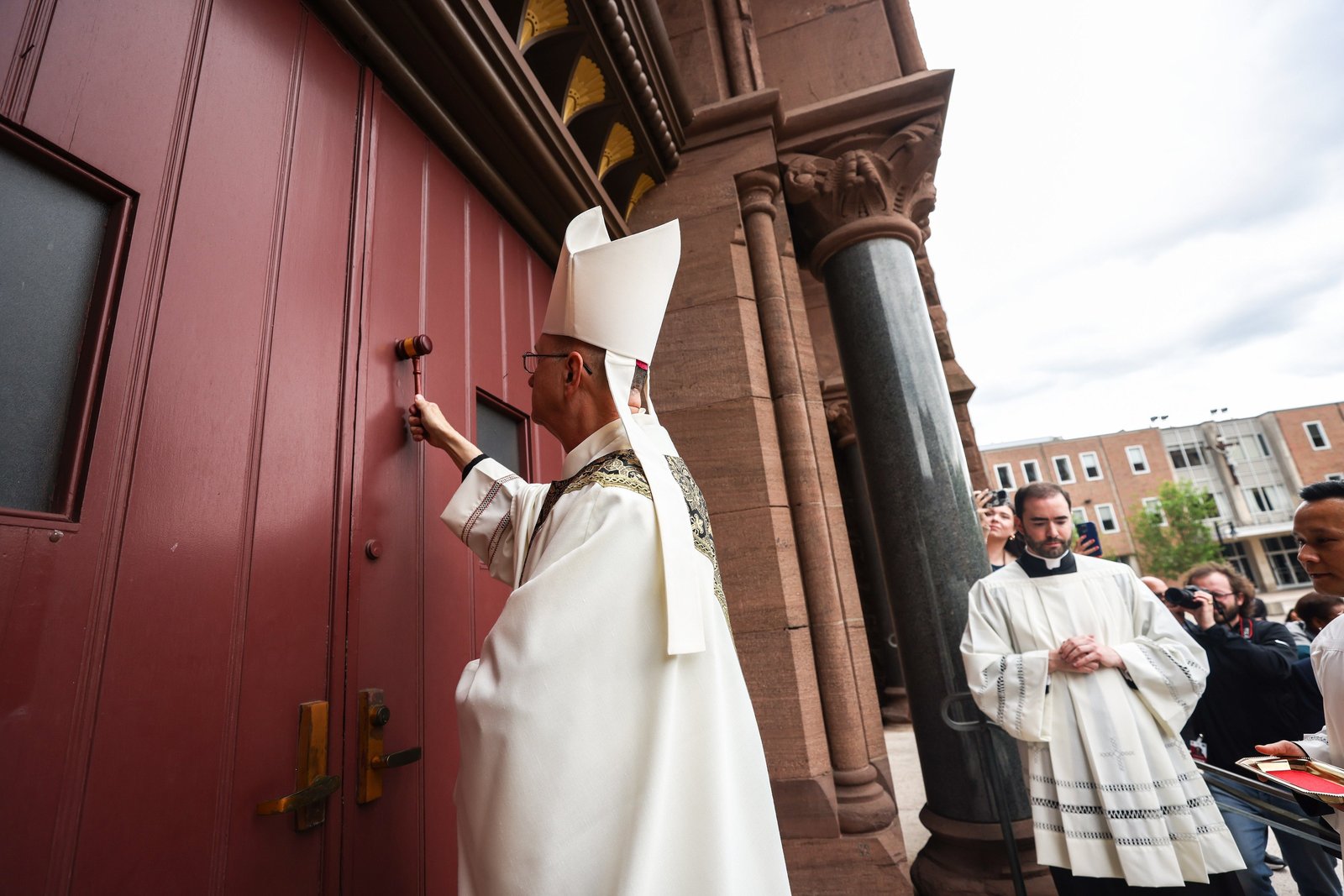Bishop Bruce A. Lewandowski, a Redemptorist, knocks on the door of the Cathedral of Sts. Peter and Paul in Providence, R.I., at the start of his installation Mass May 20, 2025. He became the 10th bishop of Providence. (OSV News photo/Laura Kilgus, Rhode Island Catholic)