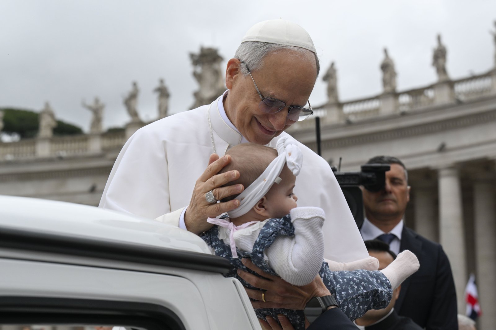 Pope Leo XIV blesses a baby as he rides in the popemobile around St. Peter's Square at the Vatican before his first weekly general audience May 21, 2025. (CNS photo/Vatican Media)