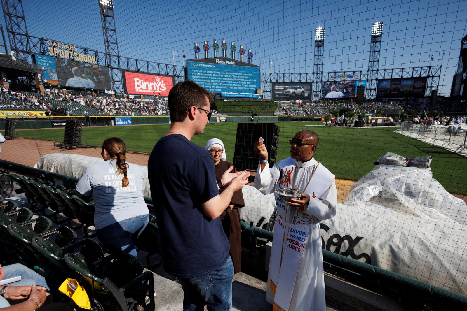 A clergyman distributes Communion during a June 14, 2025, Mass in honor of Pope Leo XIV at Rate Field in Chicago, home of the Chicago White Sox baseball team. The Chicago-born pontiff, elected May 8, is the first American pope in history. (OSV News photo/Carlos Osorio, Reuters)