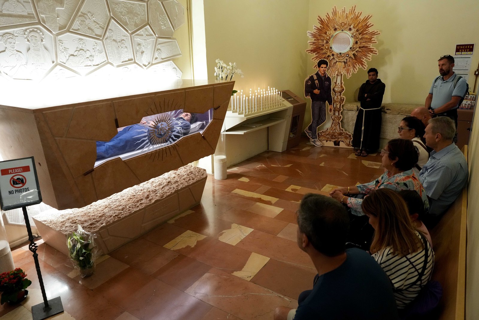 Personas rezan ante la tumba del beato Carlo Acutis en el Santuario de la Renuncia, en Asís, Italia, el 21 de agosto de 2025. Acutis, quien murió en 2006 a los 15 años, será canonizado el 7 de septiembre en el Vaticano por el papa León XIV. (Foto CNS/Lola Gomez)