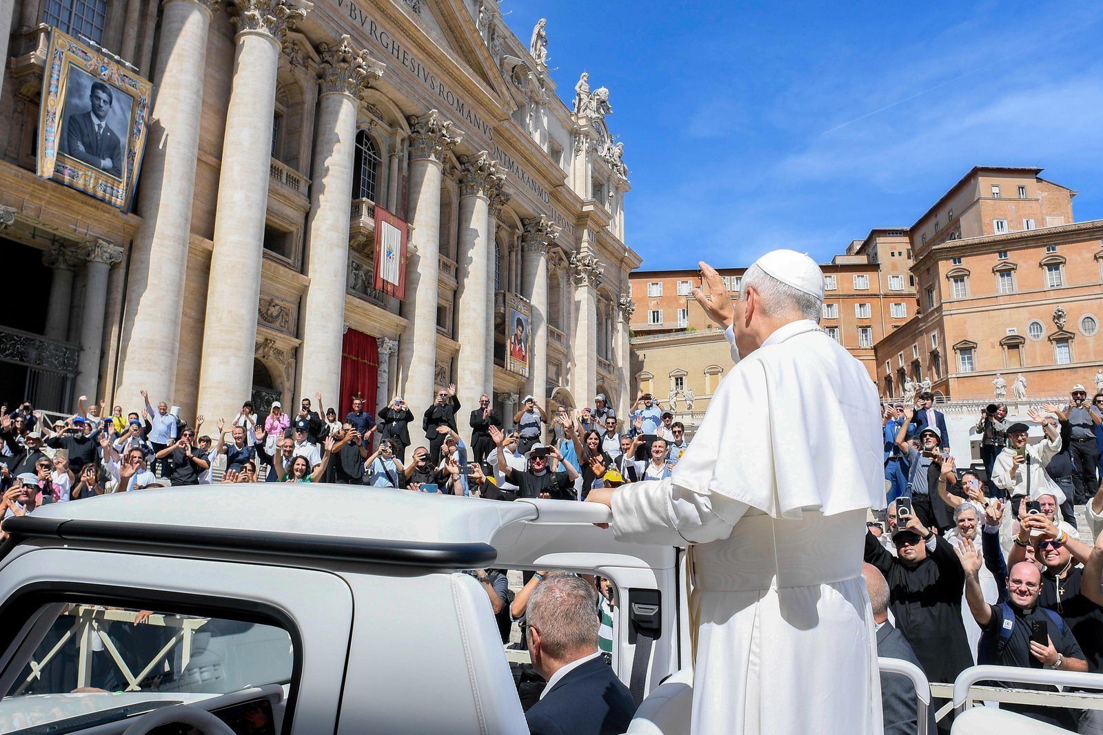 El papa León XIV saluda a los peregrinos desde el papamóvil al concluir la Misa de canonización en la Plaza de San Pedro, en el Vaticano, el 7 de septiembre de 2025. En la fachada de la basílica de San Pedro se exhiben los estandartes con los retratos oficiales de los nuevos santos, Pier Giorgio Frassati y Carlo Acutis. (Foto CNS/Medios Vaticanos)
