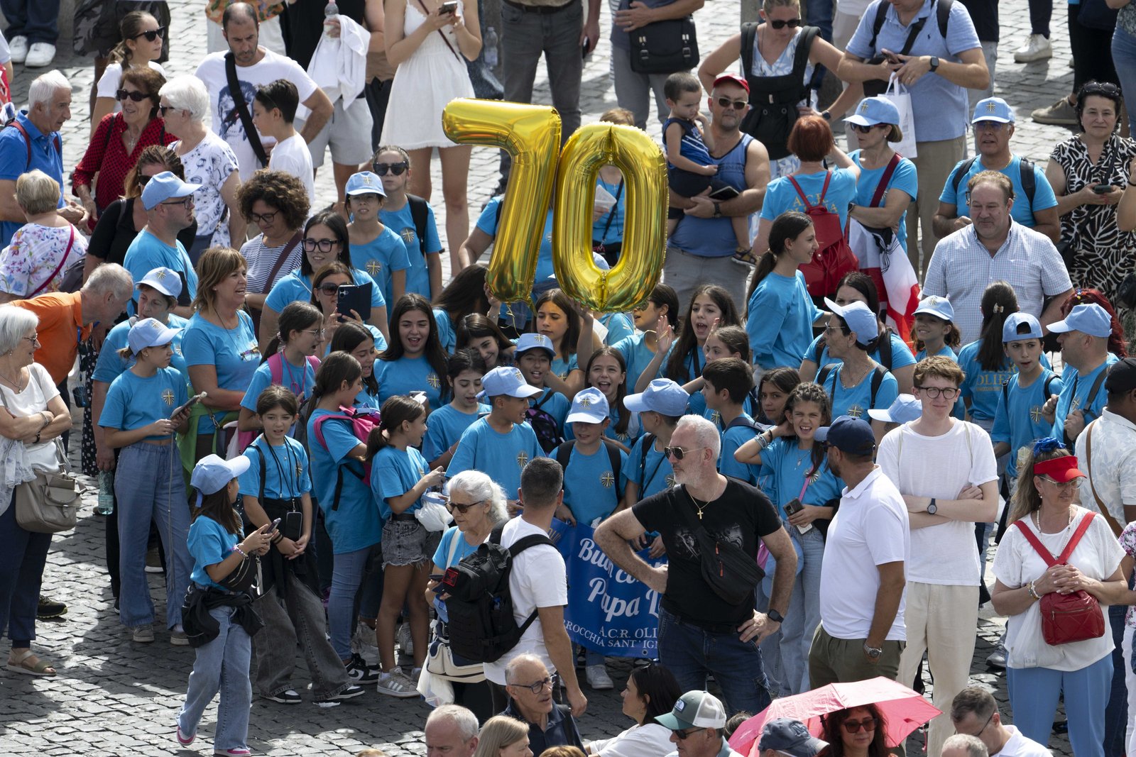 A group of children from an Italian parish holds up two gold mylar balloons of the numbers "7" and "0" as they join other visitors in St. Peter's Square at the Vatican for Pope Leo XIV's recitation of the Angelus prayer and to wish him a happy 70th birthday Sept. 14, 2025. (CNS photo/Vatican Media)
